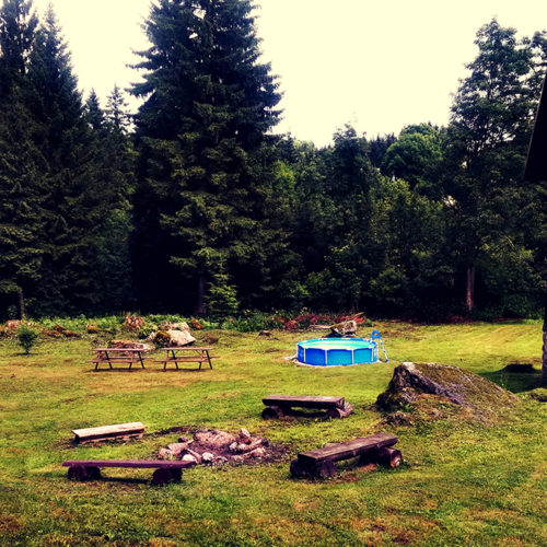 Pohled od ohniště na venkovní posezení i s bazénem